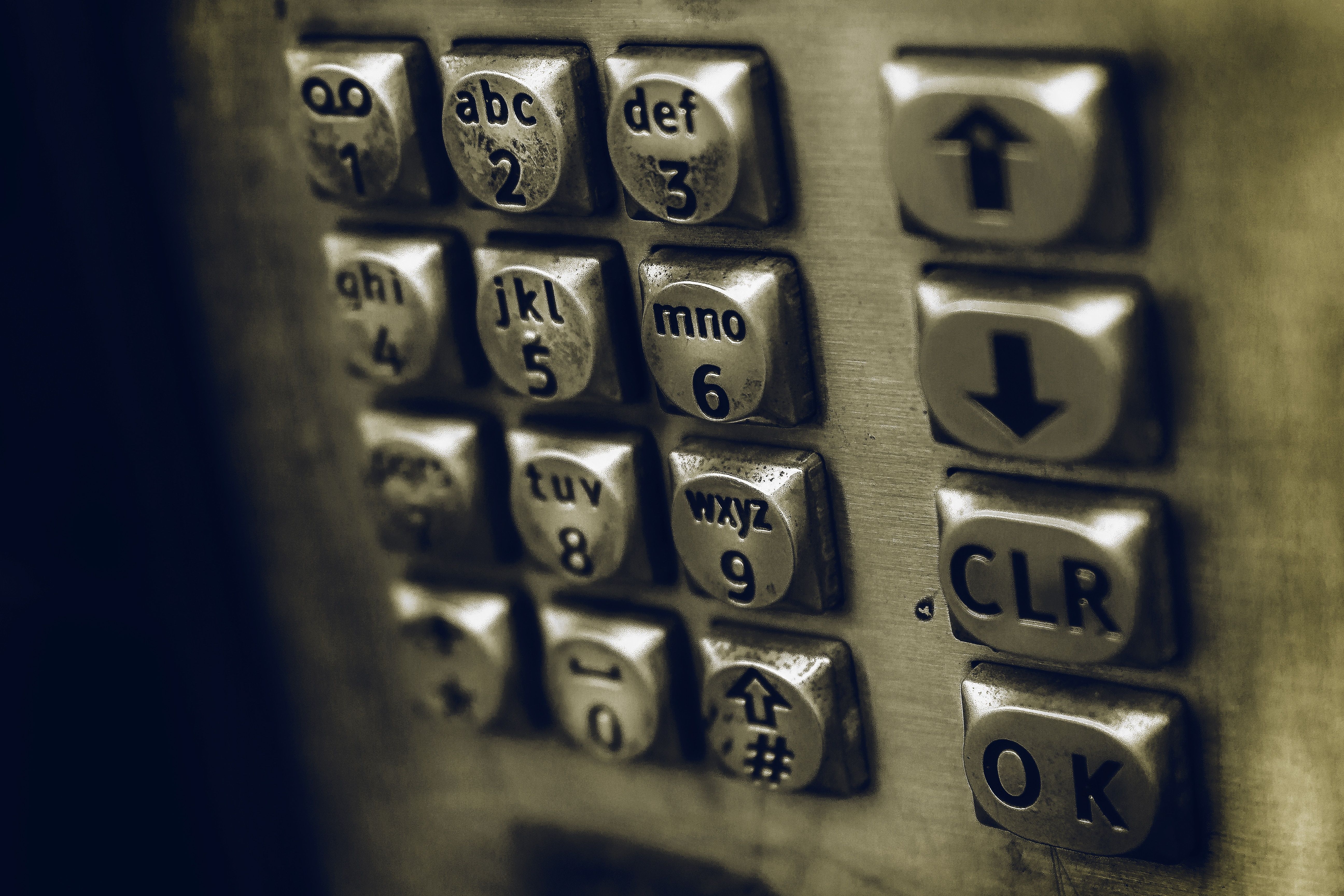 A close up of an old pay phone's keypad representing graphic conversation