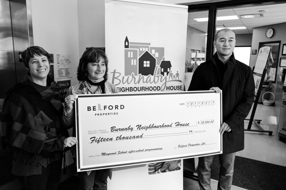 Belford presenting Burnaby Neighbourhood House with a cheque, featuring donations from the metrotown hoarding project 