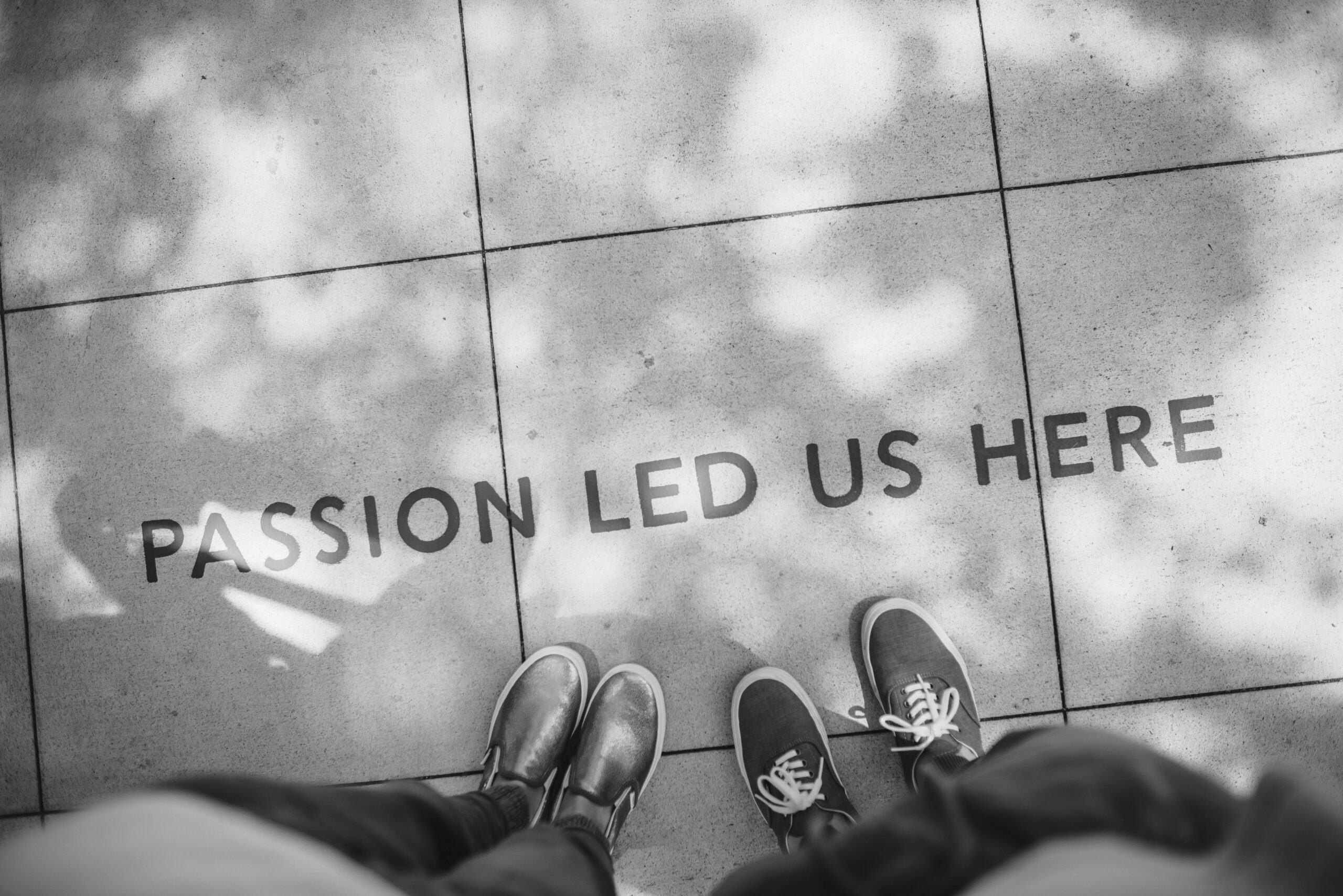 two sets of feet on the street with a quote infront of the feet that says "Passion led us hear"